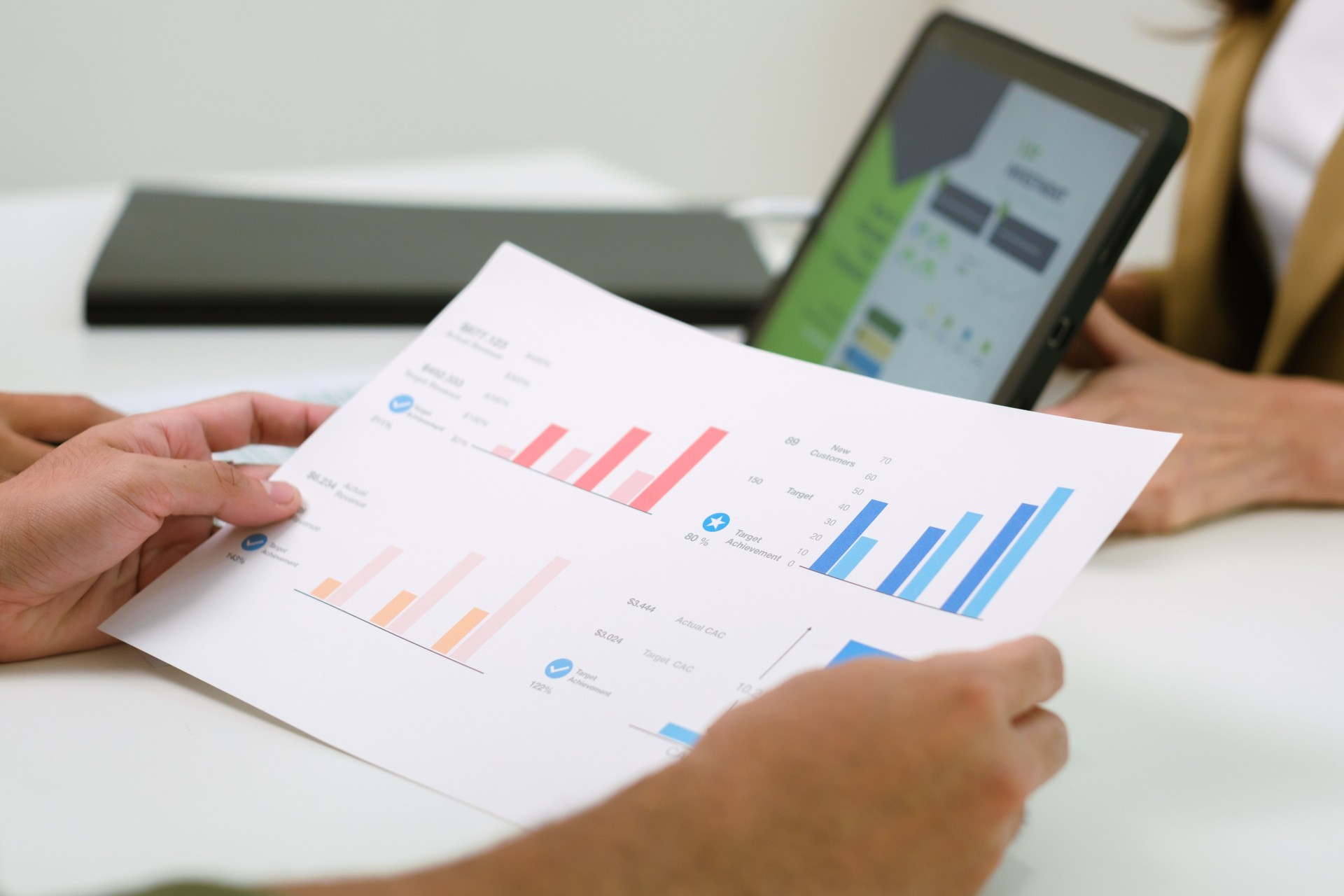 asian financial advisor presenting charts and data on a tablet during couple client meeting.financial planning and decision-making